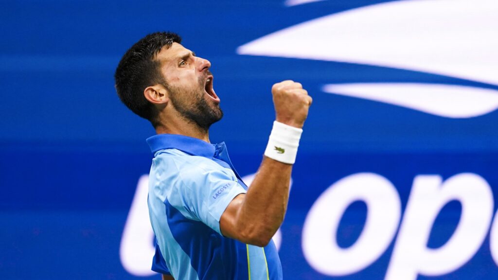 Novak Djokovic pumps his fist and yells.
