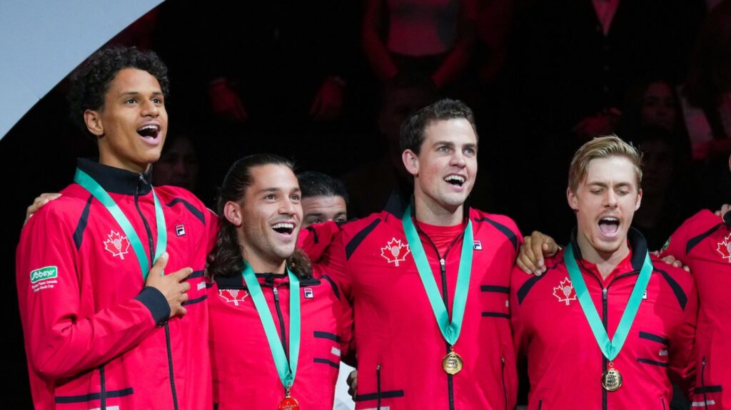 Gabriel Diallo, Alexis Galarneau, Vasek Pospisil and Denis Shapovalov stand arm-in-arm and sing the national anthem.