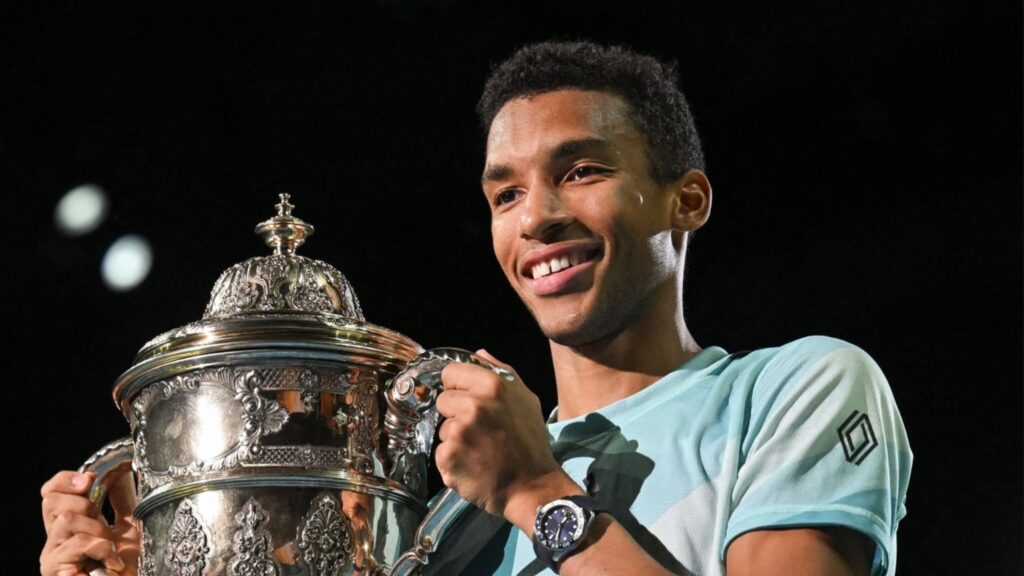 Felix Auger-Aliassime holds the Basel trophy.