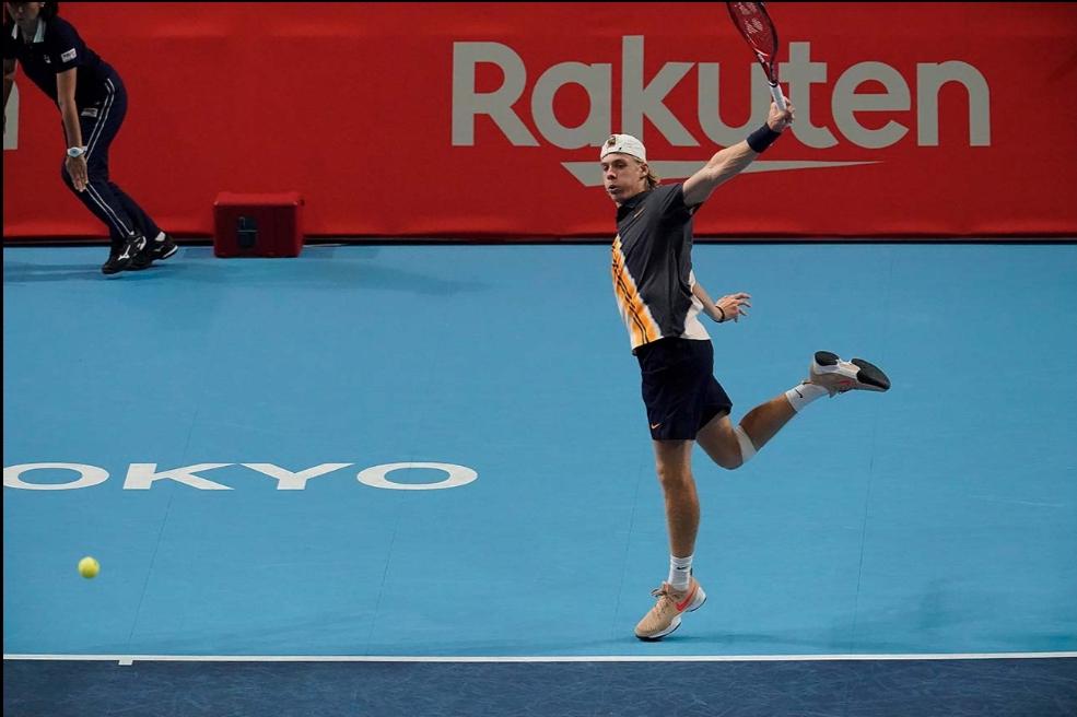 Wide shot of Denis Shapovalov following through on a backhand.
