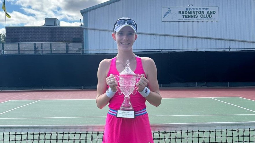 Kayla Cross stands on court and holds up her Saskatoon trophy. She, Mia Kupres, and Ariana Arseneautl were the champions.