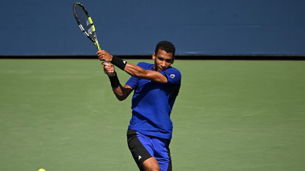 Felix Auger-Aliassime follows through on a backhand.