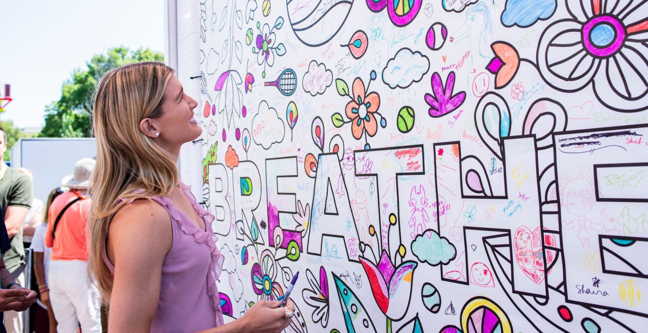 Eugenie Bouchard looks up at the positive court pledge mural.