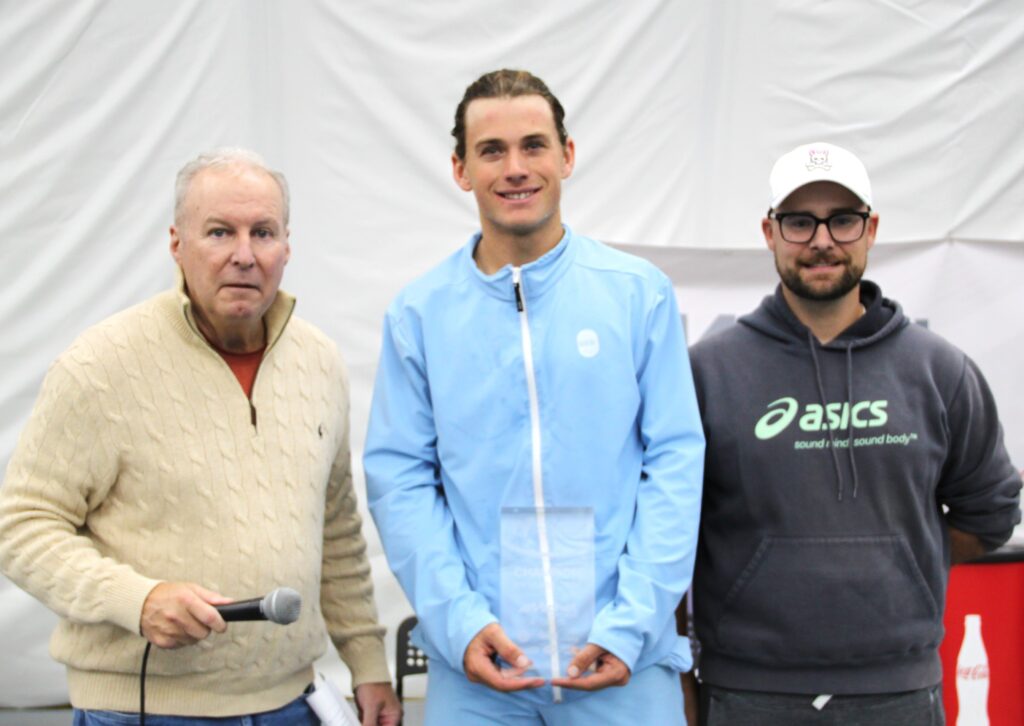 Liam Draxl (centre) holds his trophy after beating Alexis Galarneau in the final of the ITF event in Saint-Augustin.