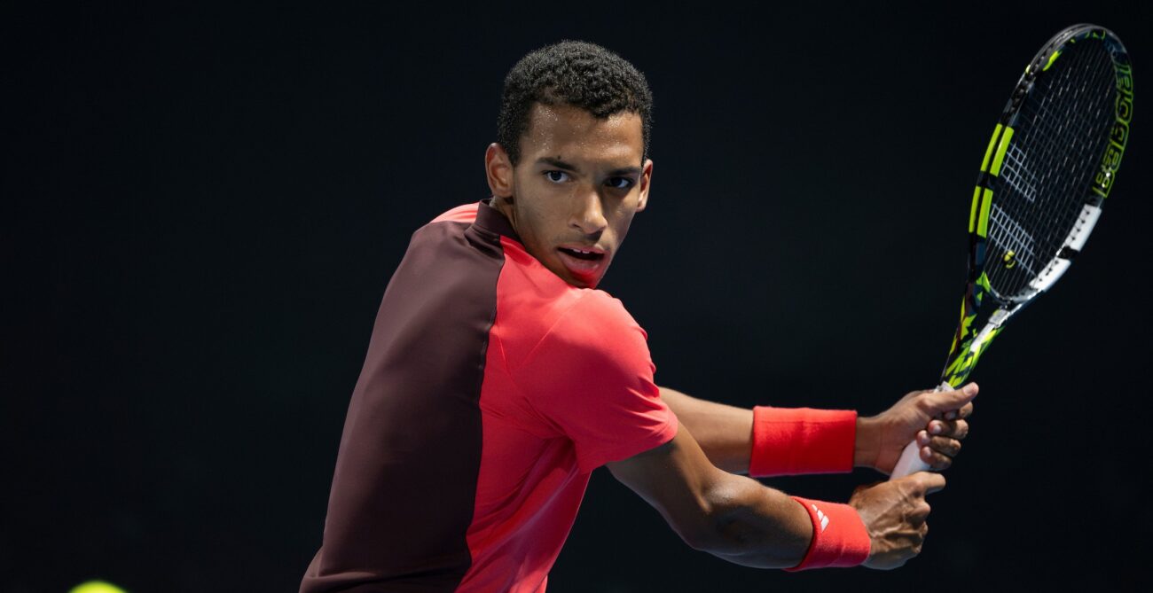 Felix Auger-Aliassime winds up to hit a backhand. Rublev Doha